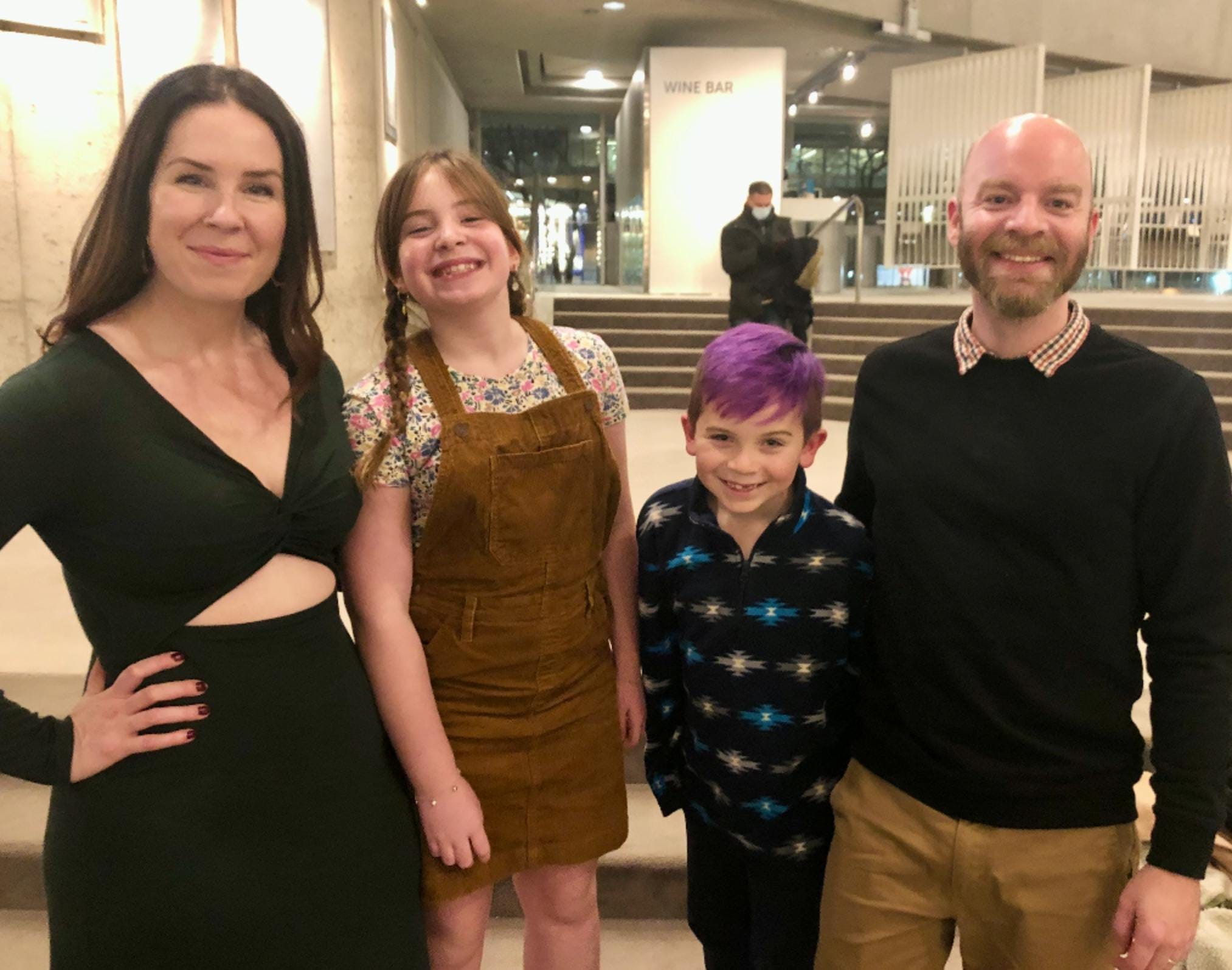 The family of mother, father, daughter and a son is posing to the camera.