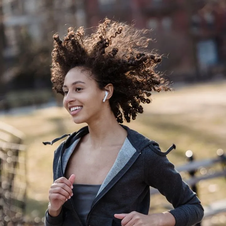 A woman running with earbuds in